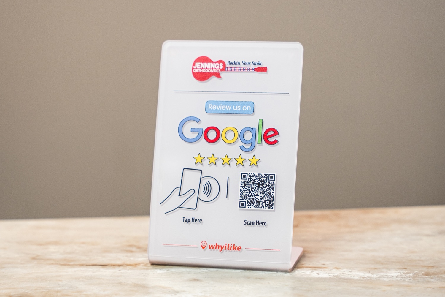 The WhyILike review stand, custom-branded for Jennings Orthodontics, on a practice counter